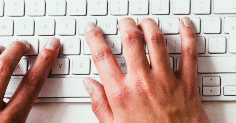 Woman's hands typing at keyboard